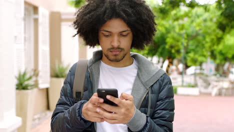 hombre africano serio usando su teléfono