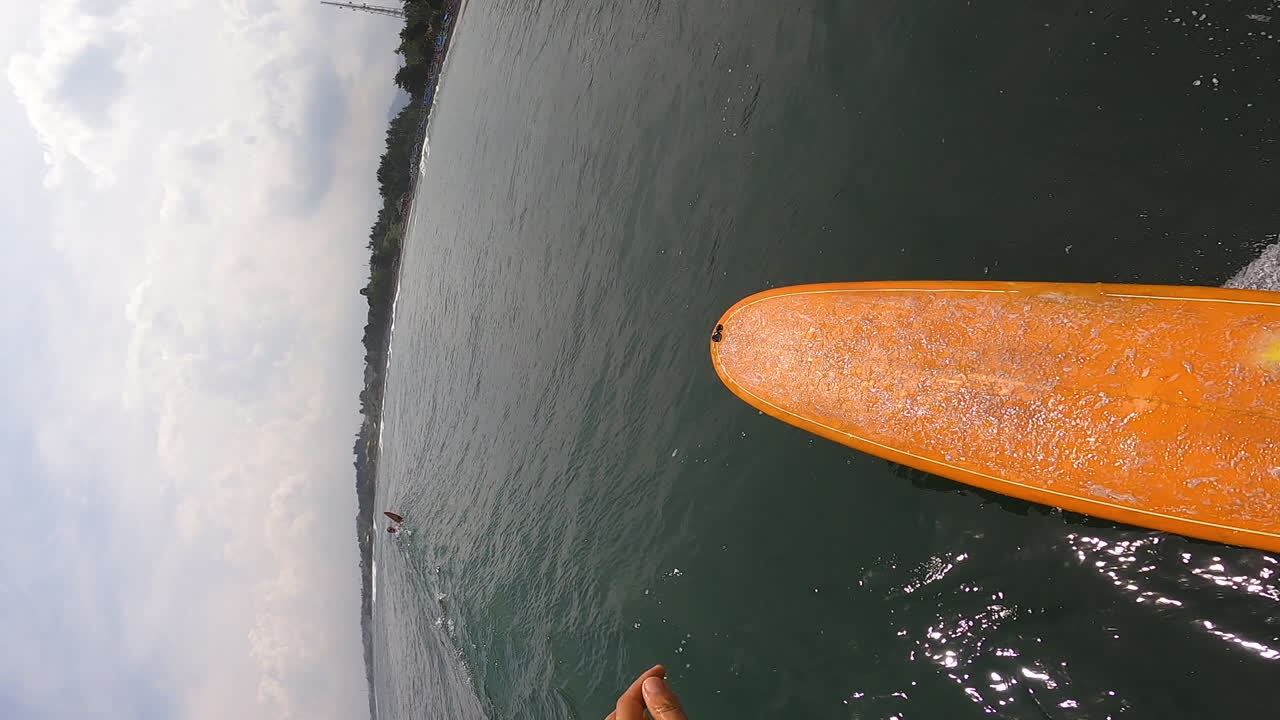 pov surf en bali con tabla de surf naranja, malhumorado día nublado