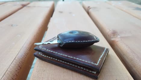 leather car key and wallet on a picnic table