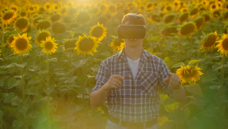 Un-Agricultor-Moderno-Y-Progresista-En-Un-Campo-Con-Girasoles-Utiliza-Tecnología-Vr.-Simulando-La-Interfaz-De-Usuario-De-La-Aplicación.-Controlar-El-Sistema-De-Riego-Con-Drones.-Inspeccionar-El-Campo-Utilizando-Drones.