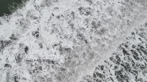 waves crashing onto shore causing white foam, playa hermosa, puntarenas