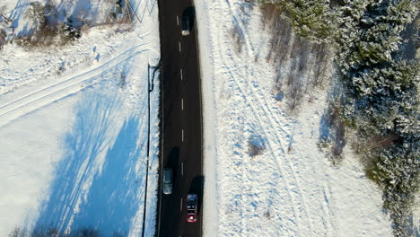 mutlple cars driving in opposite directions over a two lanes road cleared from snow in a winter wonderland near gdansk poland on a sunny day