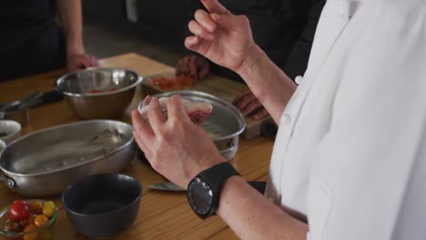 cocinera caucásica que enseña a un grupo diverso