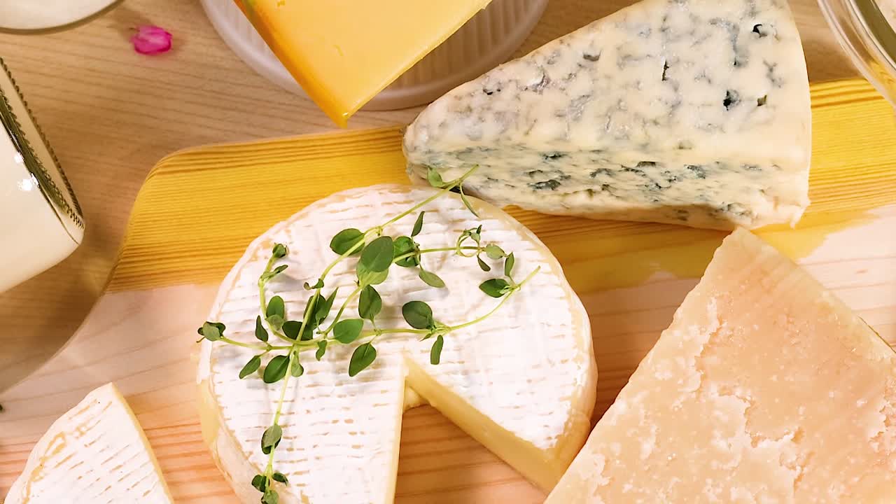 A curated display of various cheeses, including blue and soft varieties, on a rustic wooden surface.