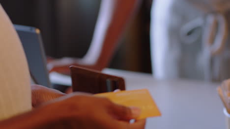 african-american-woman-using-credit-card-making-payment-friendly-cashier-serving-customer-spending-money-on-wireless-transaction-buying-coffee-supporting-small-business-cafe-close-up-hands