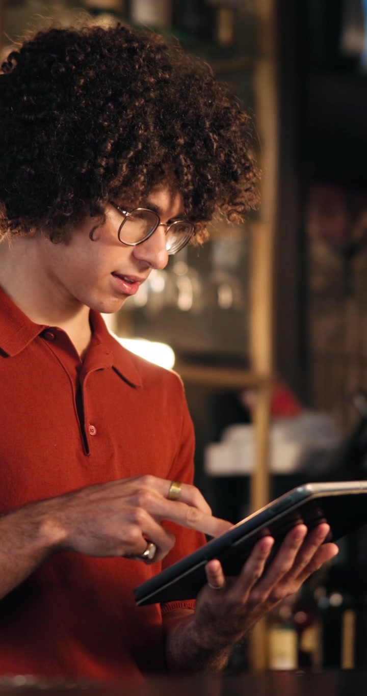 Young Man Using Digital Tablet in Cafe