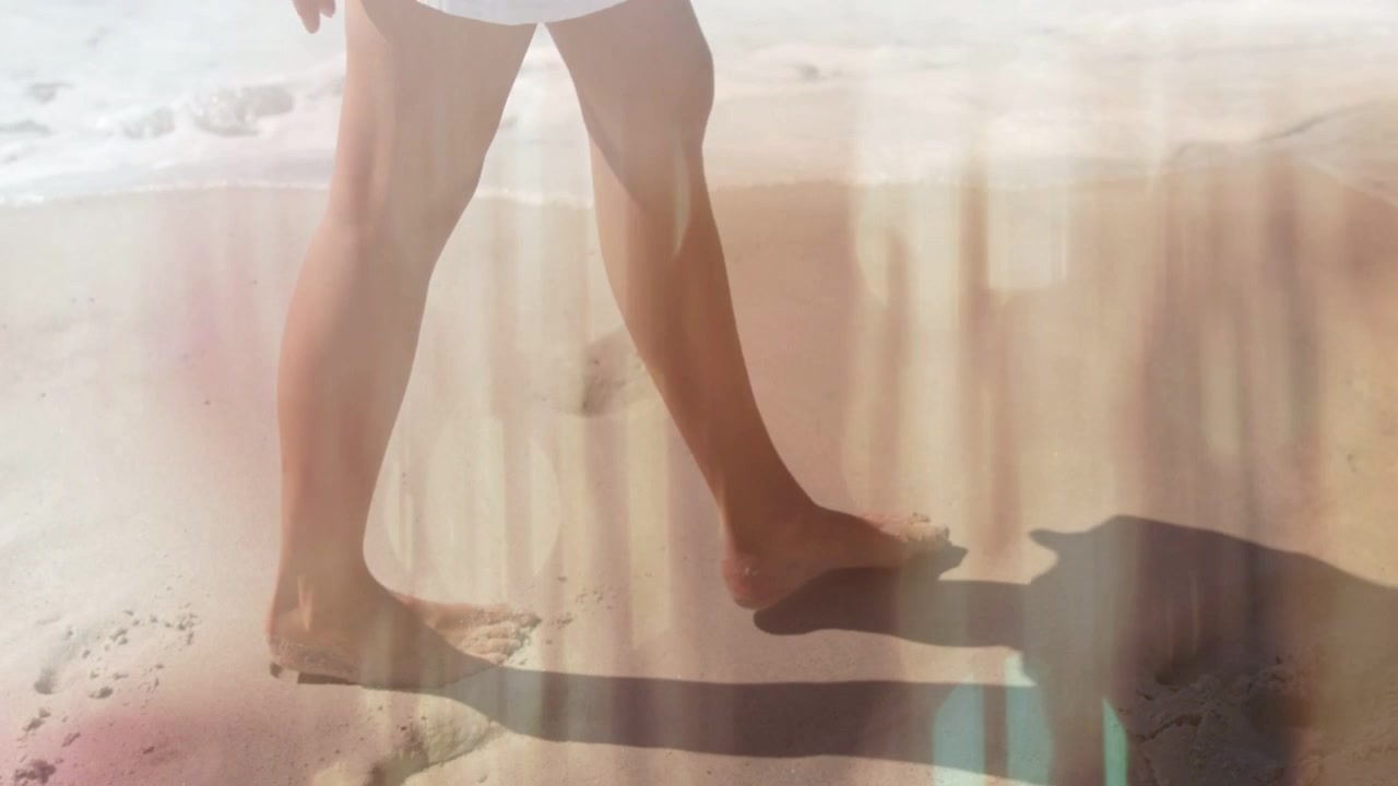 Uomo che cammina su una spiaggia sabbiosa, piede nudo che tocca terra iniziando la camminata, fughe di luce che tracciano impronte per il viaggio
