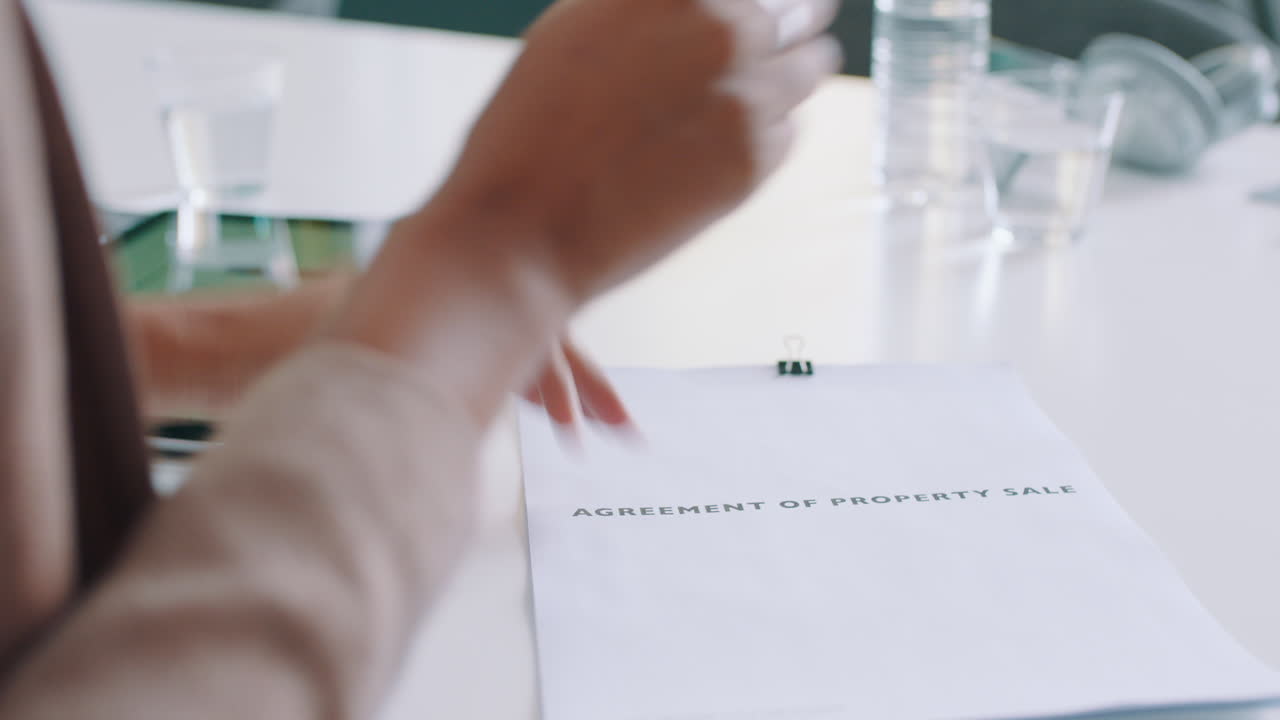 Profesionales de negocios firmando un acuerdo de compraventa de propiedad y dándose la mano