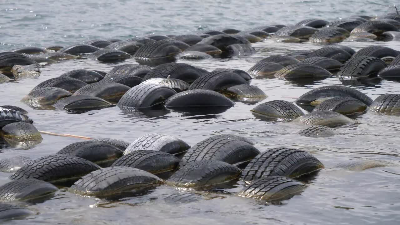 Slowly Going Past Rows Of Floating Rubber Breakwater In Lake Michigan. Tracking Shot