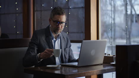 businessman working on laptop in a cafe