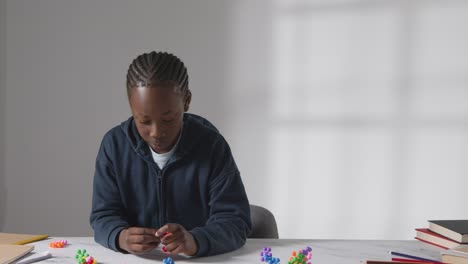 close up of boy on asd spectrum playing with shape puzzle on white background