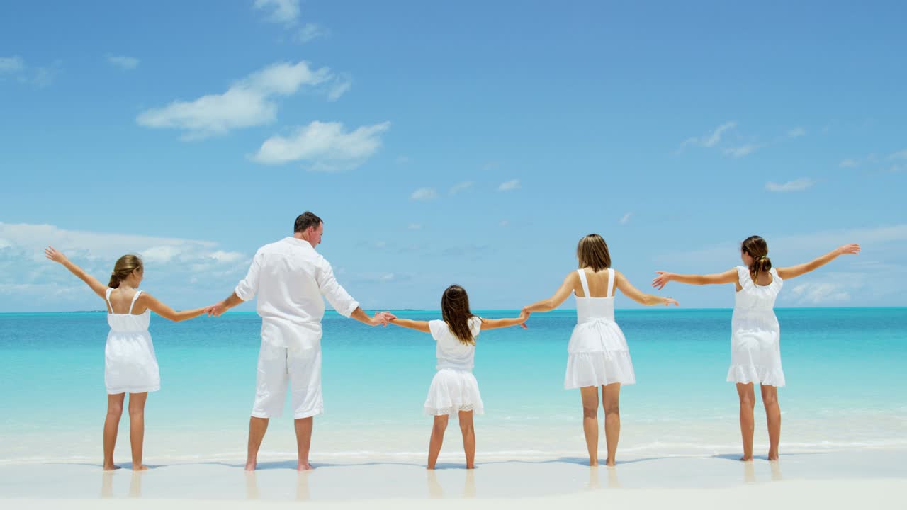 백인 부모 와 그 들 의 여자 자녀 들 이 해변 을 즐기고 있다