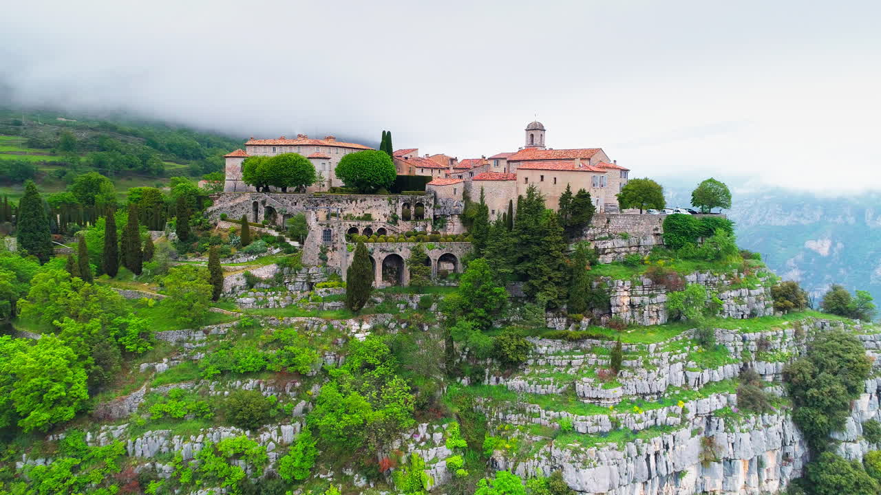 흐린 날 동안 프랑스의 산꼭대기에 있는 아름다운 역사적인 주택과 건축물 - 항공 역방향 비행 - gourdon, france
