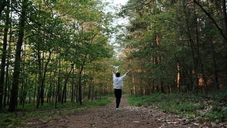 女人慢慢地在森林的小路上跳舞