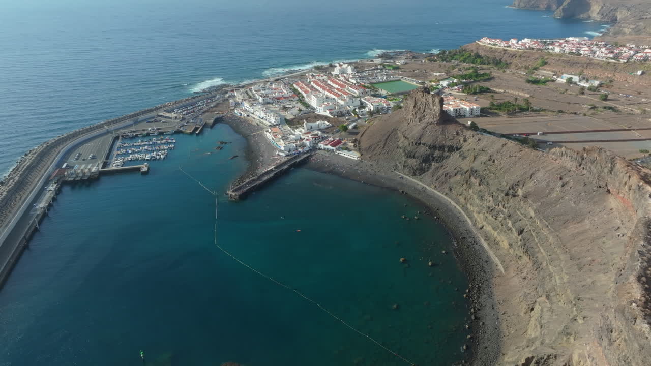 Aerial view of Puerto de las Nieves village in Agaete. Beautiful coastal town of Puerto de las Nieves with its white houses and dark beach on Gran Canaria