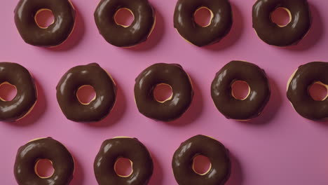 chocolate glaze donuts on a pink background
