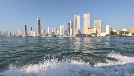 Scenic-boat-ride-along-Bocagrande,-Cartagena,-Colombia,-blue-skies-overhead-and-city-skyline-as-your-backdrop