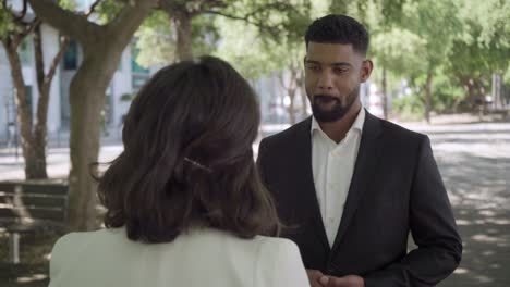 Confident-employees-standing-on-street-and-communicating