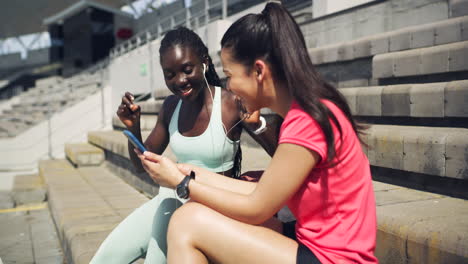 Two-sporty-women-listening-to-music-through