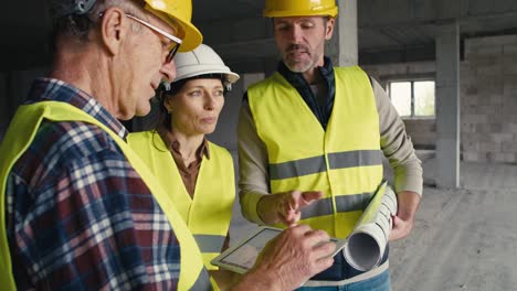 tres ingenieros caucásicos discutiendo en un sitio de construcción.