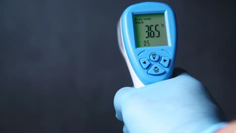 handheld digital thermometer in glove