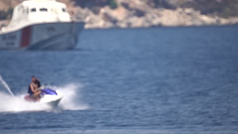 young man turning on jetski in mediterranean sea in slow motion action shot