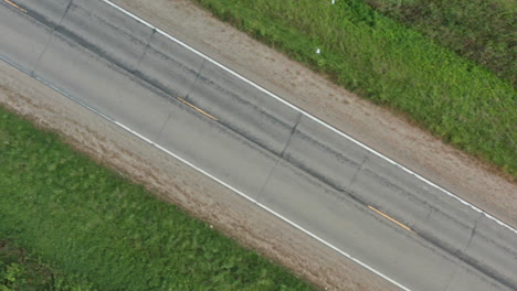 Diagonal-Aerial-View-of-Rural-Two-Lane-Road,-Drone-Flying-Right-to-Left