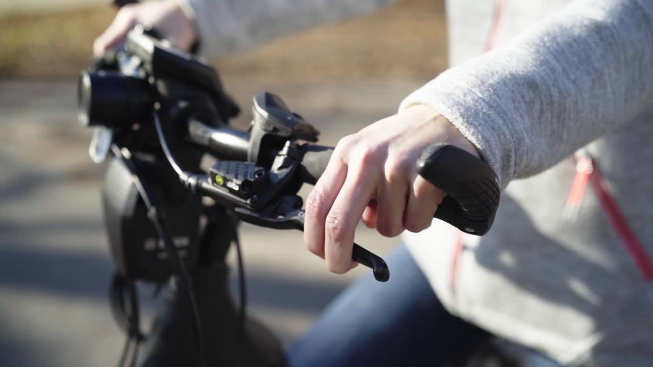 Woman pulls the brakes on the bicycle