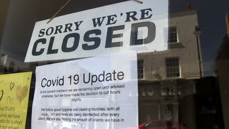 sign in beauty shop doorway advising it is closed and restricting opening hours
