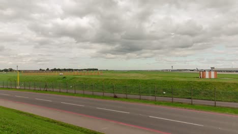 Flughafen-Zeitraffer-Mit-Startenden-Flugzeugen,-Verschwommener-Zeitraffer-Auf-Der-Hauptstraße-Im-Vordergrund