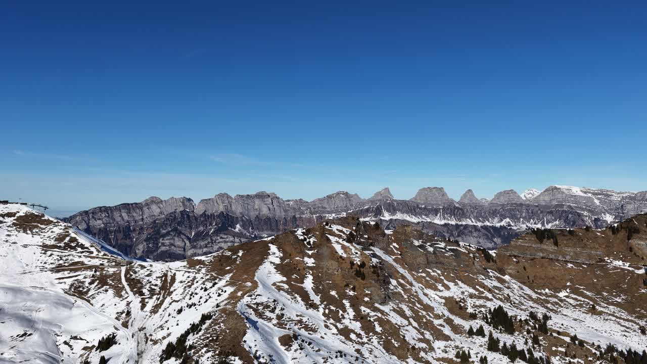 Cima rocciosa con chiazze di neve sotto un cielo azzurro limpido