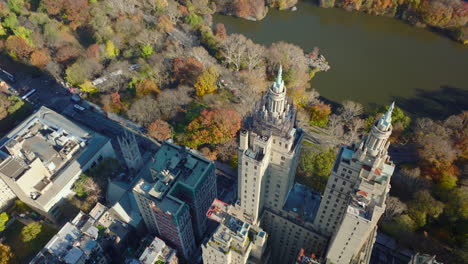 Fly-over-San-Remo-building.-Large-house-with-two-tall-towers-against-autumn-colour-trees-in-Central-Park.-Manhattan,-New-York-City,-USA