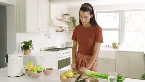 woman chopping celery in modern kitchen, preparing fresh ingredients for cooking