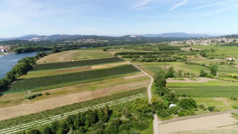 Aerial-view-of-road-passing-through-lush-green-field