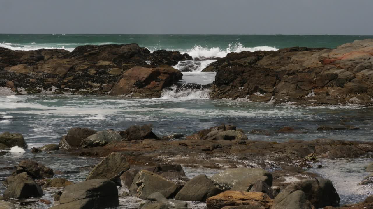las olas del océano se lavan sobre las rocas en una piscina
