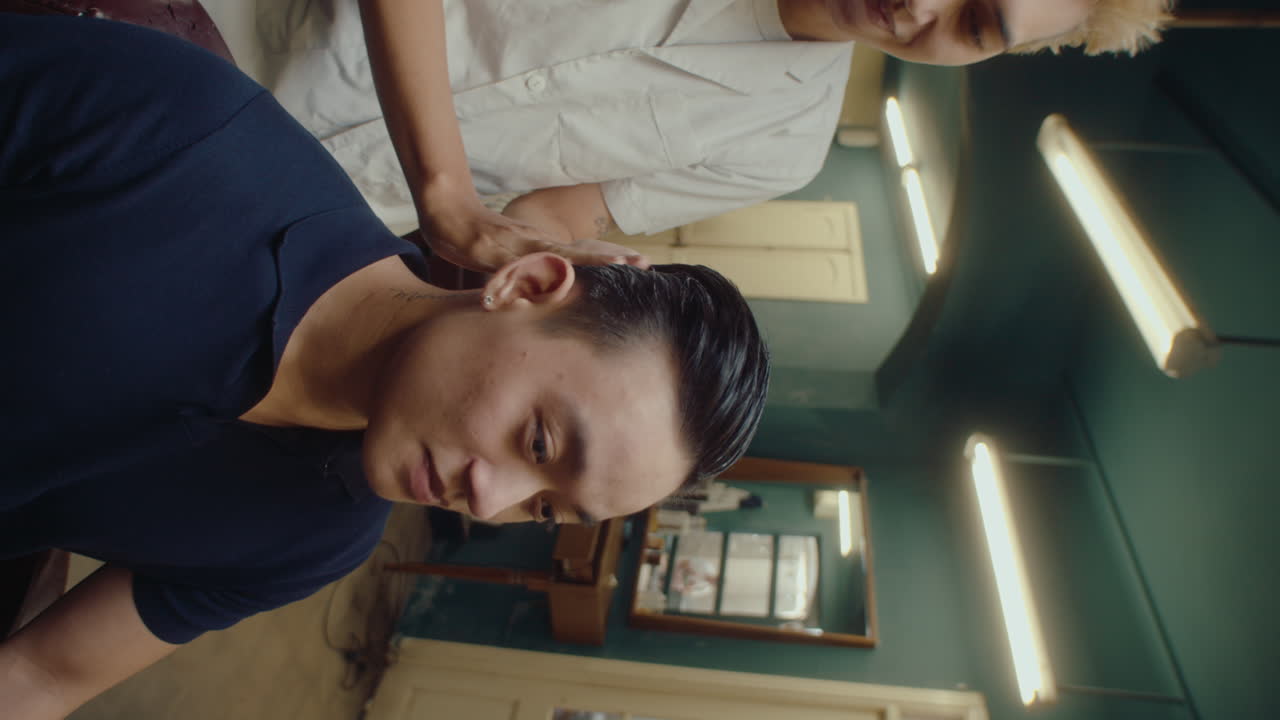 Asian Barber Styling Hair of Male Client in the Barbershop