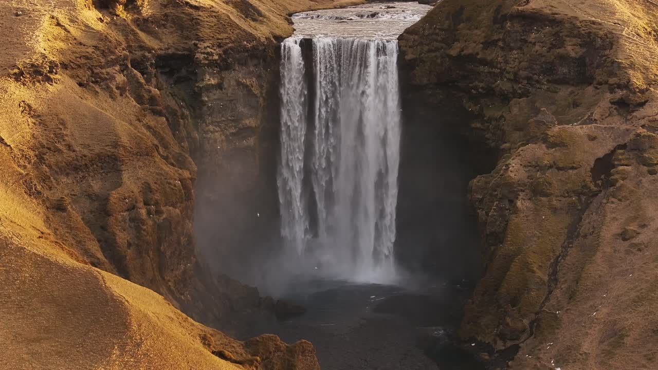 Majestic view of Skógafoss waterfall cascading down into the river in Iceland