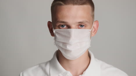 young guy putting face mask and protective glasses on