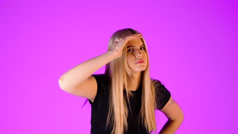 young blonde woman looking far and around gesture, studio portrait
