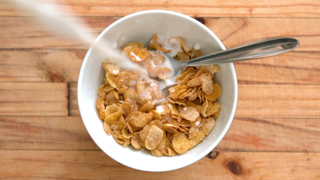 Latte che si versa in una ciotola di cereali