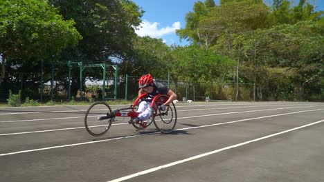 a kid with disability driving a handbike at a paracycling race, using his strength to overcome the difficulty