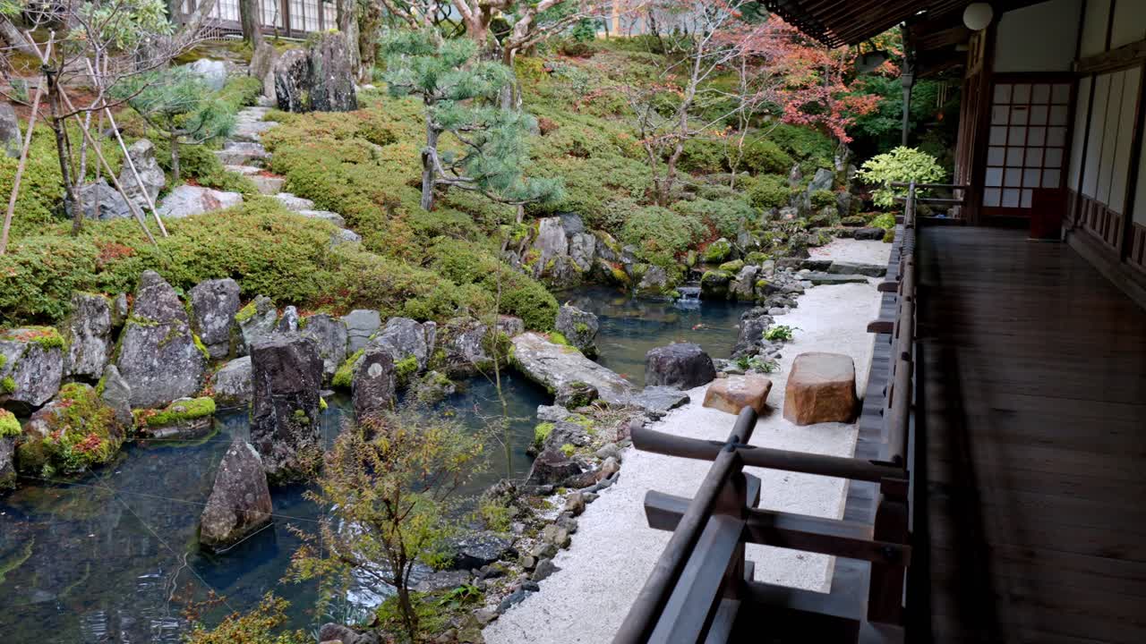 A peaceful and picturesque scene of the inner courtyard of a traditional ryokan in Koyasan, Japan. The garden pond is home to colourful koi fish swimming amidst vibrant greenery.