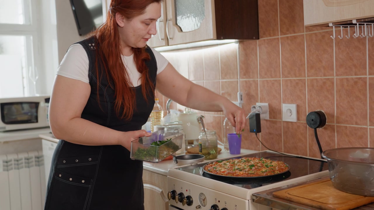 Una giovane donna è in piedi davanti al fornello a gas, mescolando una padella con un cucchiaio, concentrata a rosolare il cibo durante la preparazione della cena casalinga. La scena è caratterizzata da luce calda, dettagli di cucina moderna e un'azione di cucina domestica naturale, con la giovane donna in primo piano.