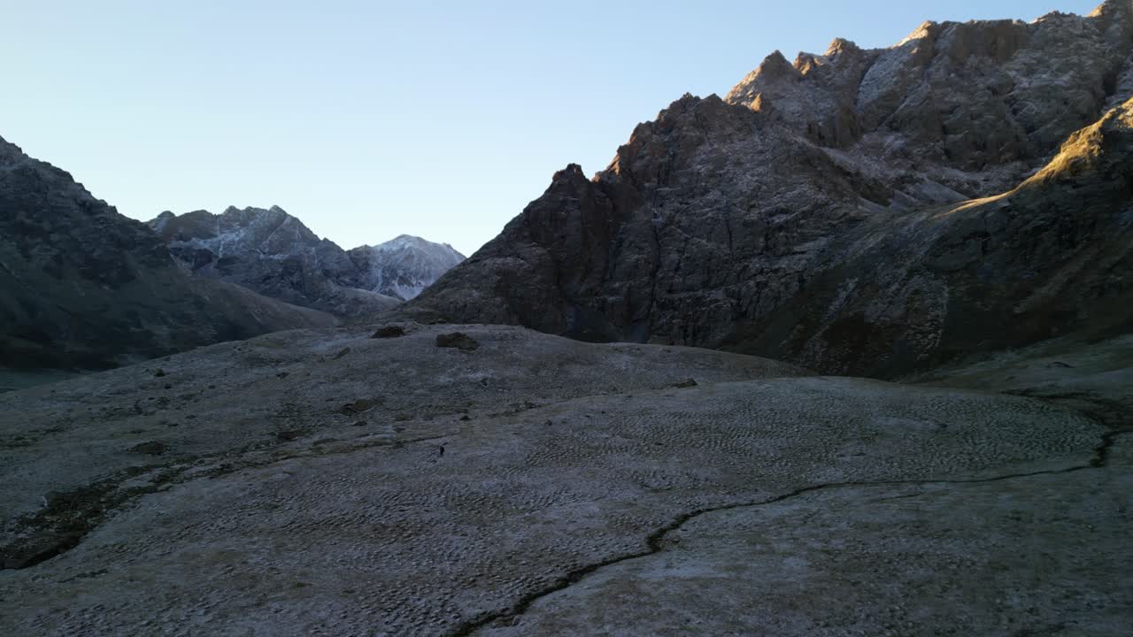 Sunrise silhouettes frost covered peaks with warm, glowing light