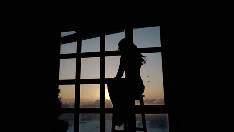 silhouette of stressed woman in darkness against sunset