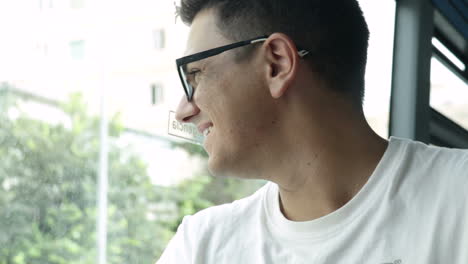 man with glasses looking out the window