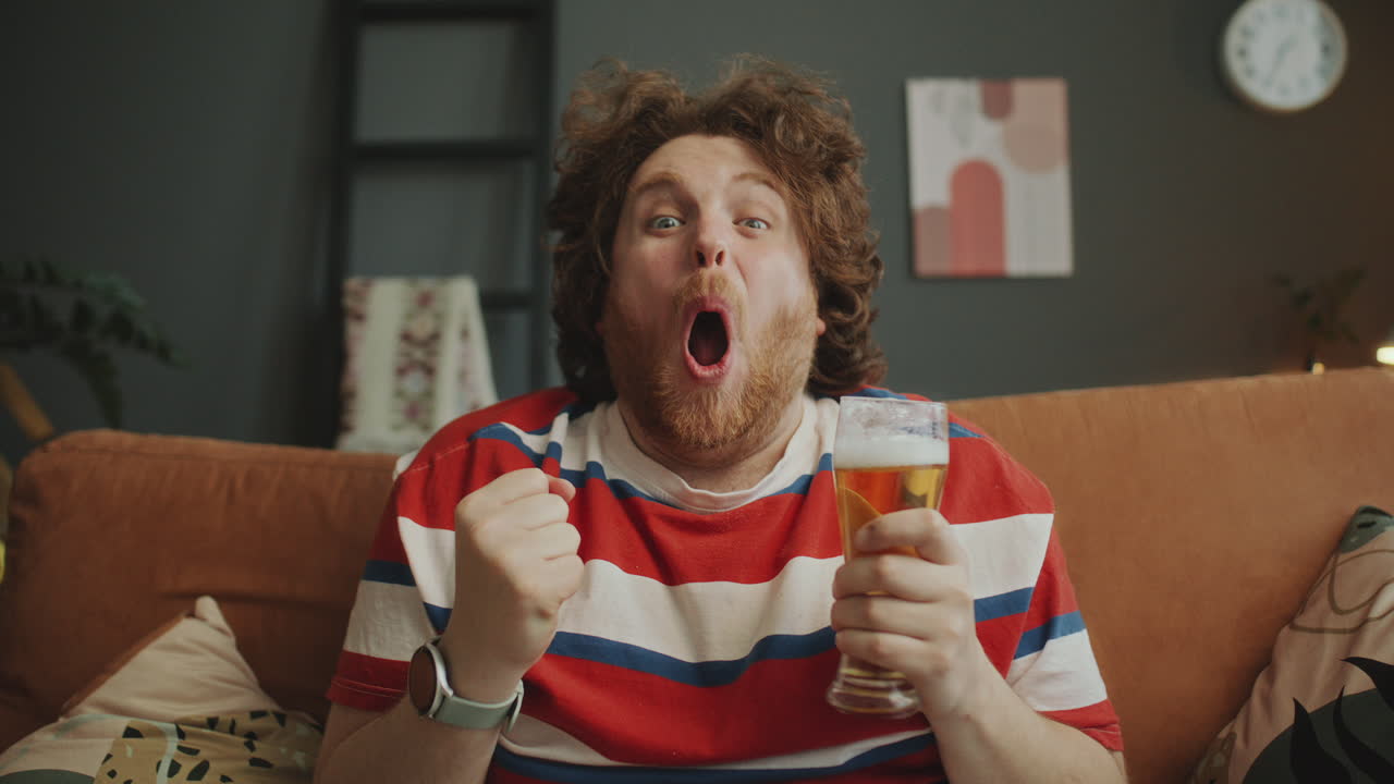 Excited Man Celebrating a Sports Victory with Beer
