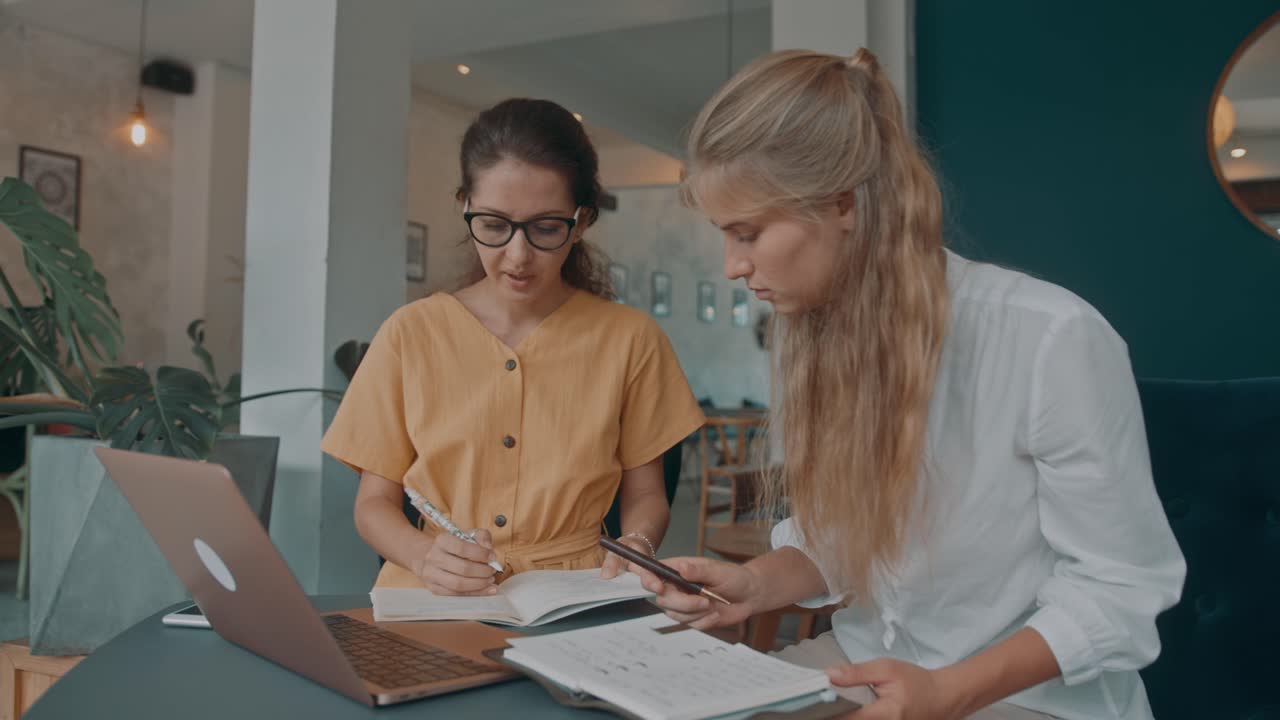 Two Women Collaborating in a Cafe
