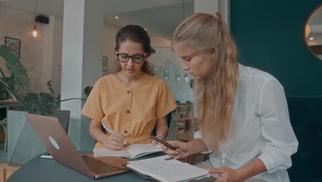 two women collaborating in a cafe