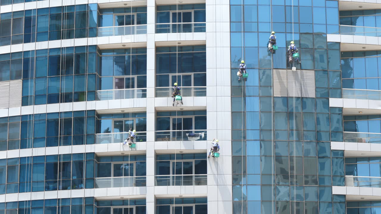 limpiadores de ventanas trabajando, trabajo peligroso, edificio alto rascacielos de cristal